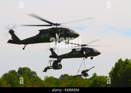 Zwei UH-60 Black Hawk Hubschrauber der 101St Combat Aviation Brigade, Luftlandedivision, Sling-Haubitzen. Stockfoto