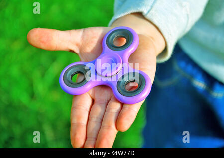 Hält die Spinner in seiner Hand. Stockfoto