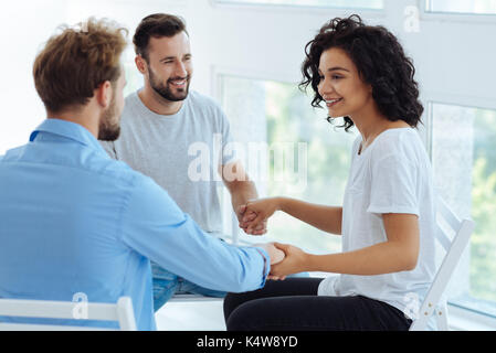 Freundliche nette Therapeuten halten sich an den Händen ihrer Patienten Stockfoto