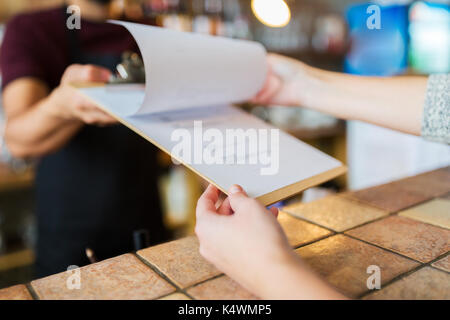 Barkeeper, Menü, um Kunden an der Bar Stockfoto
