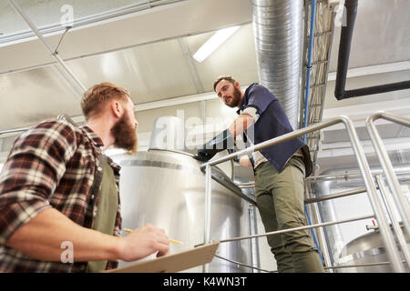 Männer mit Zwischenablage an Brauerei Bier oder Anlage Wasserkocher Stockfoto