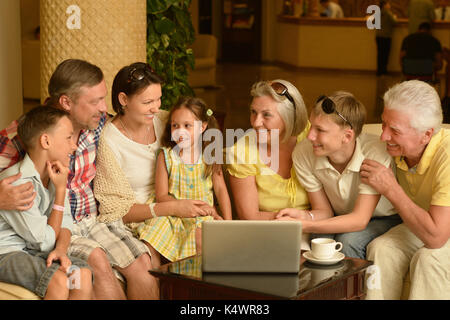 Familie sitzt auf der Couch Couchtisch mit Laptop Stockfoto