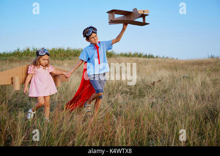 Bruder und Schwester in Anzügen von Superhelden Piloten gehen in n Stockfoto