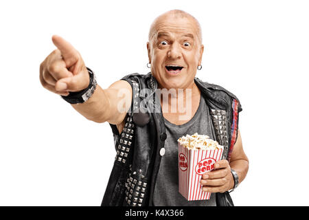 Ältere Punker mit einem Popcorn Box zeigen und auf weißem Hintergrund lachen isoliert Stockfoto