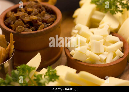 In Scheiben geschnitten Cheddar Käse und Rosinen in Ton Schalen Stockfoto