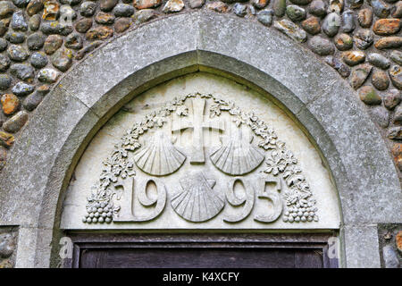 Modernes Mauerwerk mit den drei Jakobsmuscheln Symbol des Hl. Jakobus in der Pfarrkirche von St. James an Southrepps, Norfolk, England, UK. Stockfoto