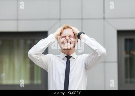 Schlechte Emotionen und Gefühle. Kopfschmerzen. Geschäftsmann berühren Kopf und haben eine Migräne. Außenaufnahme Stockfoto