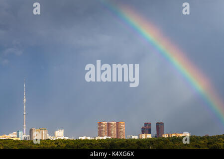 Sonnenstrahlen und Regenbogen in den regnerischen Himmel über der Stadt Moskau mit Fernsehturm und Timiryazevskiy städtischen Park Stockfoto