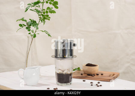 Kaffee tropft im vietnamesischen Stil auf hölzernen Tisch Stockfoto
