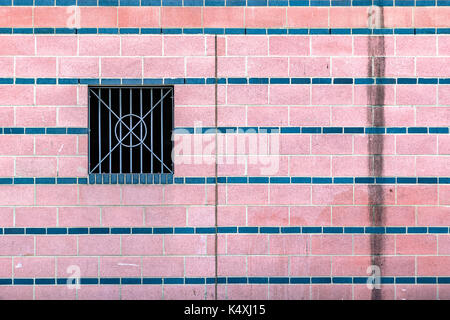 Rosa Fliesen- wand mit schmutzigem Wasser Flecken und einem vergitterten Fenster für Konzept verwenden Stockfoto