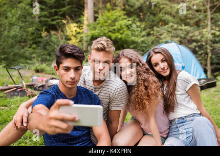 Jugendliche vor Zelten im Wald. Stockfoto