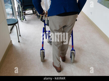 Ein älterer Mann zu Fuß hinter seiner Gehhilfe Stockfoto