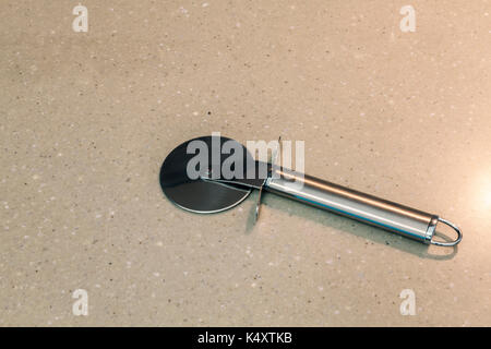 Metall Messer zum Schneiden der Pizza auf einer Marmorplatte Stockfoto