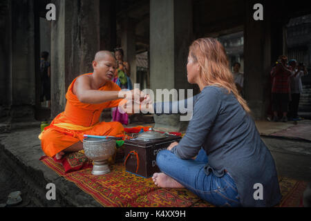 Ein Tourist an der Tempelanlage Angkor Wat erhält ein Segen von einem buddhistischen Mönch. Die Tempelanlage ist in Siem Reap, Königreich Kambodscha entfernt. Stockfoto