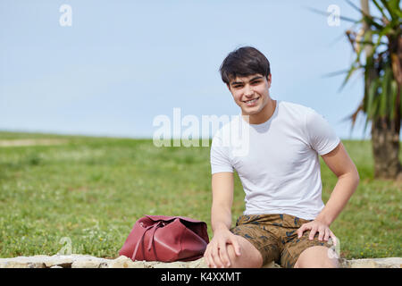 Vordere Portrait von jungen Menschen gerne draußen sitzen mit Rucksack Stockfoto