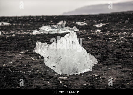 Eis auf einem schwarzen Strand in Island liegen, Ozean Küste in der Nähe der Gletscherlagune Jokulsarlon. Stockfoto