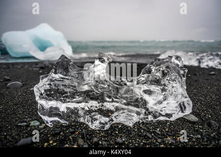 Eis auf einem schwarzen Strand in Island liegen, Ozean Küste in der Nähe der Gletscherlagune Jokulsarlon. Stockfoto