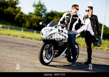 Mann und Frau tragen Lederjacken und stilvolle Sonnenbrillen reiten auf Motorrad Stockfoto