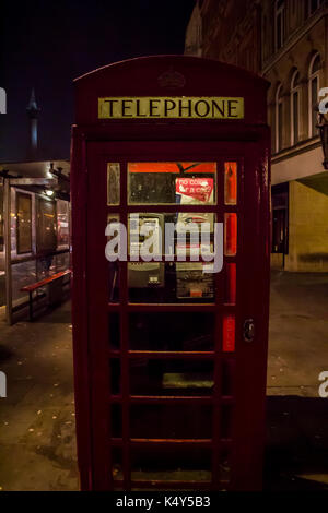 Vereinigtes Königreich, England, London - 2017 Januar 23: Beliebte touristische rote Telefonzelle in der Nacht leuchten Beleuchtung auf der Straße Stockfoto