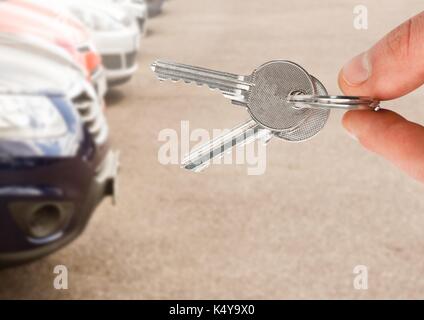 Digital composite von Hand mit Schlüssel vor Autos Stockfoto