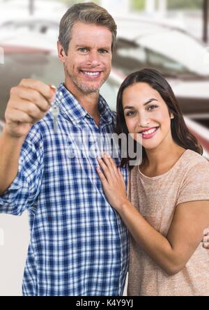 Digital composite von Paar Gedrückthalten der Taste vor Autos Stockfoto