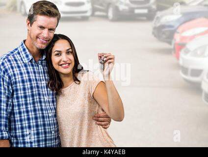 Digital composite von Paar Gedrückthalten der Taste vor Autos Stockfoto