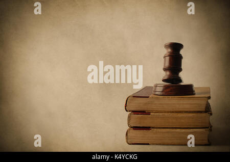 Rechtlicher Begriff. Eine hölzerne Hammer auf einem Haufen von alten, vergilbten Bücher. Im Alter von Pergament Hintergrund und Vignette für Vintage Effekt. Stockfoto