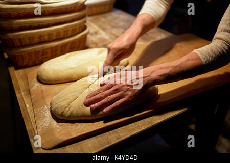 Bäcker, Brot und schneiden Teig bei Bäckerei Stockfoto