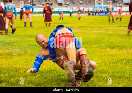 Ulaanbaatar, Mongolei - Juni 11, 2007: Ein kleiner Junge Wrestler ist auf den Boden geworfen im Ringkampf im National Stadion an der Naada Stockfoto