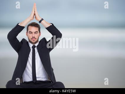 Digital composite Business man meditieren gegen blurry Strand Stockfoto