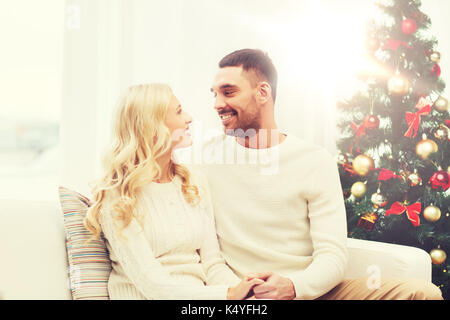 glückliches Paar zu Hause mit Weihnachtsbaum Stockfoto