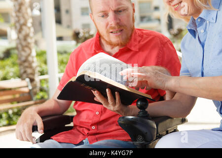 Studieren wir die Heilige Bibel zusammen. Behinderte Menschen. Stockfoto