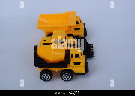 Gruppe von kleinen schwere Baumaschine Spielzeug, Lkw, Bulldozer und Betonmischer. Alle aus Kunststoff auf weißem Hintergrund. Stockfoto
