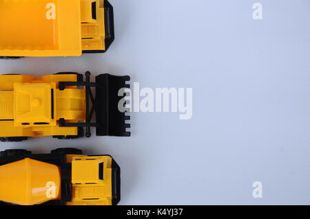 Gruppe von kleinen schwere Baumaschine Spielzeug, Lkw, Bulldozer und Betonmischer. Alle aus Kunststoff auf weißem Hintergrund. Stockfoto