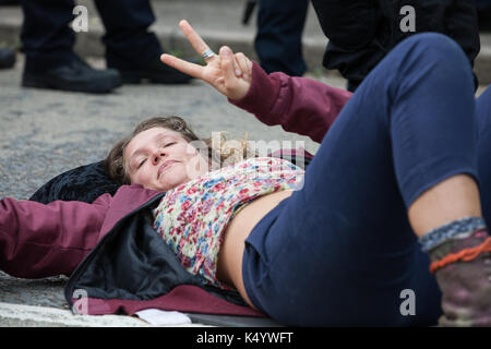 London, Großbritannien. 7. Sep 2017. Ein Mitkämpfer gegen den Waffenhandel Proteste gegen in der nächsten Woche DSEI arme Messe im ExCel Center durch Lügen in die Fahrbahn wechselte zu einem anderen Demonstrant mit einem "Lock-on"-Rohr die Zufahrtsstraße zum Einsatz militärischen Geräts, um das Ereignis in den Verkehr zu blockieren. Credit: Mark Kerrison/Alamy leben Nachrichten Stockfoto