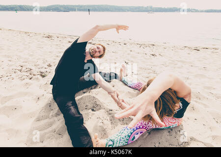 Junge passen Paar übung Yoga am Strand Dünen am frühen Morgen in Deutschland Stockfoto