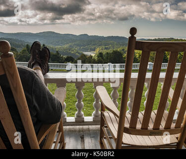 Füße hochlegen Relaxen Schaukelstuhl Veranda - Fantastische Aussicht, Wolken. Südlichen Berg Leben. Holz- Wippe, auf der Veranda mit Blick auf den See Stockfoto