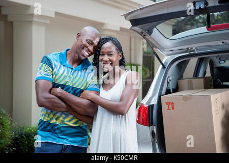 Paar neben ihrem Auto voller Boxen Stockfoto