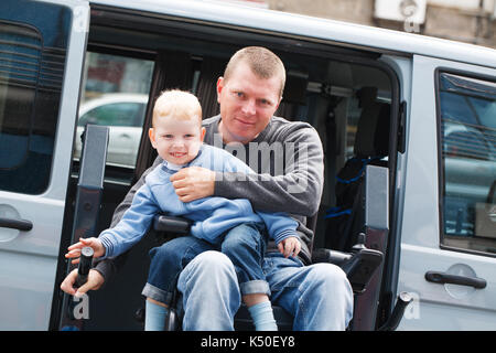 Behinderte Menschen im Rollstuhl heben mit 4 Jahre alten Sohn Stockfoto