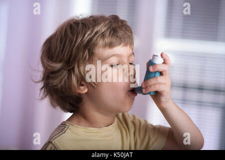 Junge mit Asthma Inhalator entzündliche Krankheit zu behandeln, pfeifende Atemgeräusche, Husten, Engegefühl in der Brust und Atemnot. Allergie Konzept behandeln. Stockfoto