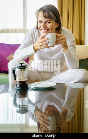 Reife Frau genießt frisch gebrühten Kaffee am Morgen Stockfoto