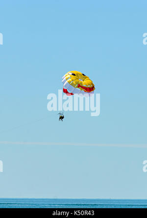 Farbige parasail Flügel mit einem Boot im Meer Wasser gezogen, auch bekannt als Parasailing oder parakiting Parasailing. Stockfoto