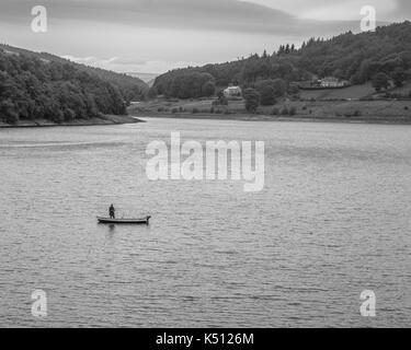 Einsame Fliegenfischer auf Ladybower Reservoir. Fischer in einem kleinen See Boot Fliegen, Fischer im Boot trieb die Linie. Stockfoto