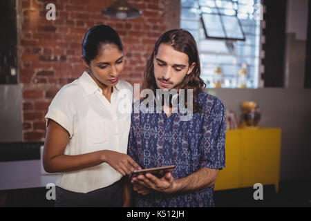 Junger Mann, Tablet-PC, Freundin, während im Coffee shop Stand Stockfoto