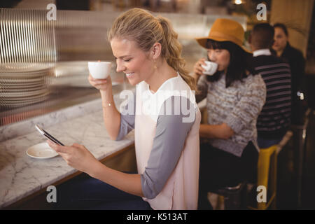 Junge Kunden Kaffee trinken, während im Cafe sitzen Stockfoto