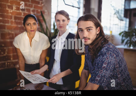 Portrait von selbstbewussten jungen kreativen Team stehen mit Dokumenten im Coffee Shop Stockfoto