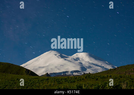 Snowy Mountain Elbrus (5642 m) im Mondlicht und Star Tracks bei Nacht Stockfoto