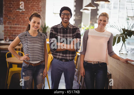 Portrait von lächelnden jungen Freunden bei Kaffee shop Stockfoto