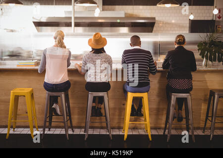 Ansicht der Rückseite des Kunden sitzen auf Hockern an der Theke im Café Stockfoto