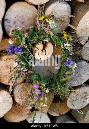 Kornblumen in Kranz auf das zerkleinerte Holz Wand Stockfoto